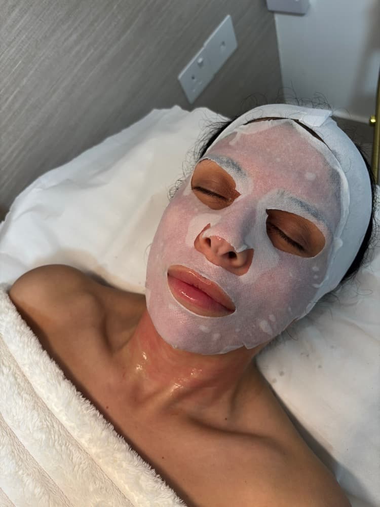 Client relaxing with a treatment mask